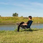 Mann auf Stuhl am Fluss